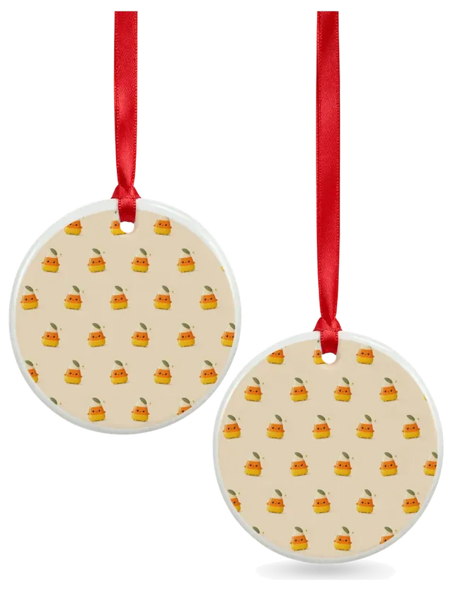 Two round ceramic ornaments on red ribbons, covered in the candy corn pattern